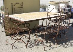A tile top rectangular garden table and five metal frame chairs.