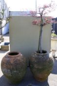 A pair of large terracotta garden pots. Of baluster form with ribbed sides.
