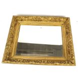 A bevelled edge wall mirror with gilt pitch pine frame. Heavily decorated with acanthus leaves.