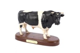 A Royal Doulton model of a Fresian Bull on an inscribed wooden base. Printed black marks, 29.