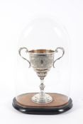 A '800' ( indistinctly marked) white metal two handled pedestal trophy with engraved decorated