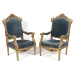 A pair of 19th Century style gilt open arm\ throne chairs with sprung seats and blue velvet