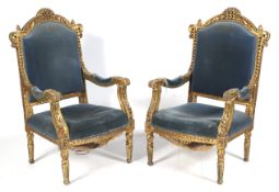 A pair of 19th Century style gilt open arm\ throne chairs with sprung seats and blue velvet