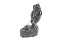 'Boma , Canada ' an Inuit/ eskimo carving of a fisherman pulling an animal out of an ice hole,