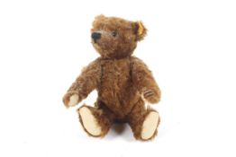 A late 20th Century dark finish Steiff Teddy bear ( wool and cotton covering with jointed arms and