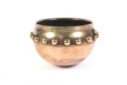 An early 20th Century brass studded and copper Glastonbury bowl, approximately 12.
