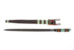 An East African leather scabbard and sword with polychromed banded decoration, the whole 64.