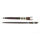 An East African leather scabbard and sword with polychromed banded decoration, the whole 64.