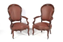 A pair of Victorian style Mahogany open arm chairs with brass stud and faux leather (vinyl)