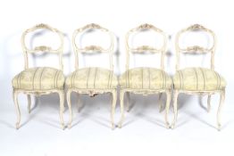 A set of four circa 1900 French painted chairs with sprung seats and floral stripped upholstery,