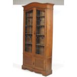 An Edwardian ( slight Arts and Crafts) bookcase with stained and leaded glass doors before an