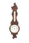 A circa 1900 carved oak two glass wall Aneroid Barometer with porcelain dial backs ,