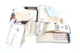 A collection of vintage world stamps, postcards, and a tin of stamps, cut-outs, etc.