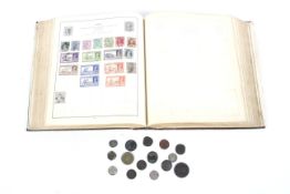 A small group of world coins and a stamp album.