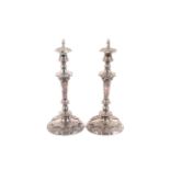 A pair of silver plated shaped-round candlesticks with flame finials,