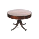 A circa 1900 Regency Style Mahogany drum table with a gold tooled red leather insert to top and