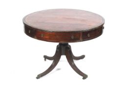 A circa 1900 Regency Style Mahogany drum table with a gold tooled red leather insert to top and