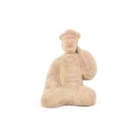 A Chinese terracotta figure of a kneeling man in Tang style with a raised arm in a voluminous