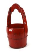 An Oriental red painted wooden well bucket.