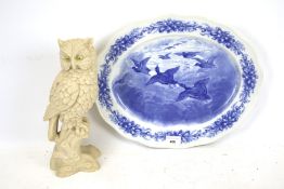 A Cauldron blue and white meat charger and an owl figurine. The charger decorated with ducks.