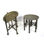 Two Anglo Indian brass tray top tables. Both on folding wooden stands.