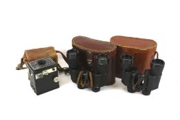 Two pairs of vintage binoculars and a box camera.