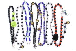 Seven various bead necklaces in sharply-contrasting colours.