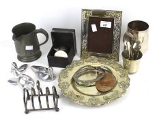 A collection of assorted vintage plated items. Including a photoframe, a toast rack and mugs, etc.