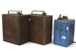 Three vintage petrol cans, one converted into a lamp.