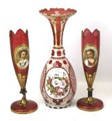 A 19th century Bohemian cranberry glass vase and a pair of smaller vases.