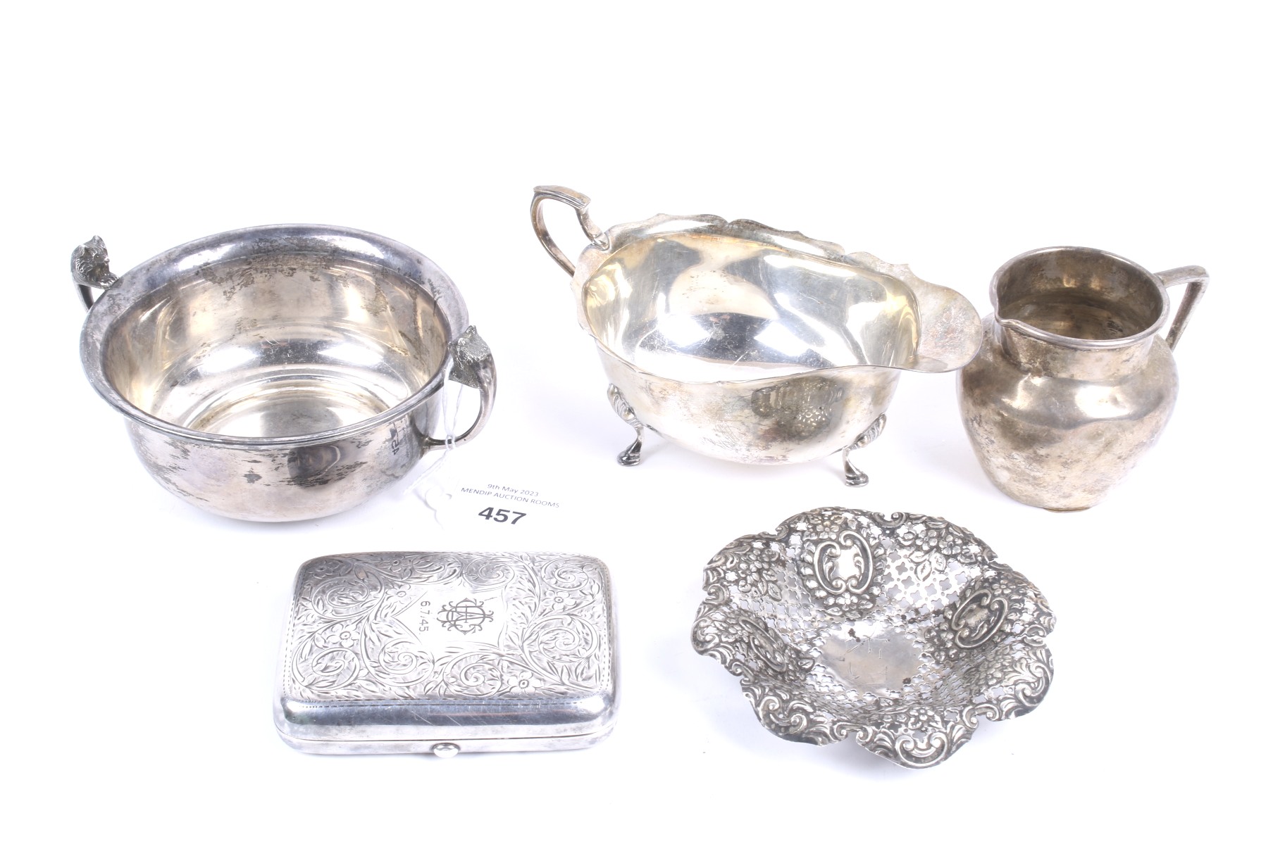 A silver sauce boat and four other items.
