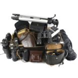 A collection of assorted vintage binoculars, cameras and tripods.