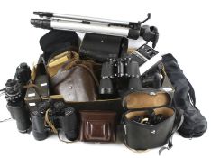 A collection of assorted vintage binoculars, cameras and tripods.