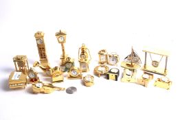 A collection of 22 assorted brass cased miniature novelty clocks/timepieces.