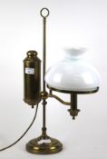 A brass oil lamp style electric table light. With white glass shade.