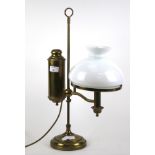 A brass oil lamp style electric table light. With white glass shade.