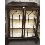 An Edwardian dark oak bow fronted display cabinet.