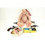 A collection of assorted toys. Including a 'Raspberry Sorbet' teddy bear, dolls, cap guns, etc.