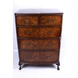 An early 20th century burr walnut bow fronted chest of drawers.