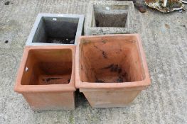 Two square stone planters and two terracotta pots.