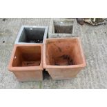 Two square stone planters and two terracotta pots.