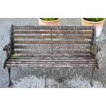 A traditional garden bench with cast iron ends and wooden slates.