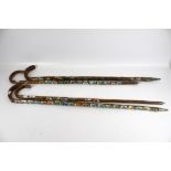 Four walking sticks attached with a collection of metal badges. Max.