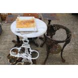 Five cast metal table bases, an umbrella stand and a circular white marble table top.