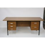 A 1970s teak veneer office desk. On square metal supports and drawers on either side.