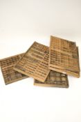 Five assorted vintage wooden printer's trays/drawers. Each drawer divided into smaller sections.