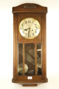 A 1930s oak cased wall clock.