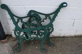 A pair of cast iron garden bench ends painted green.