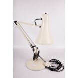 An Anglepoise model 90 desk lamp. Cream coloured with black springs on a circular base.