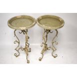 A pair of small round tables with metalwork supports.